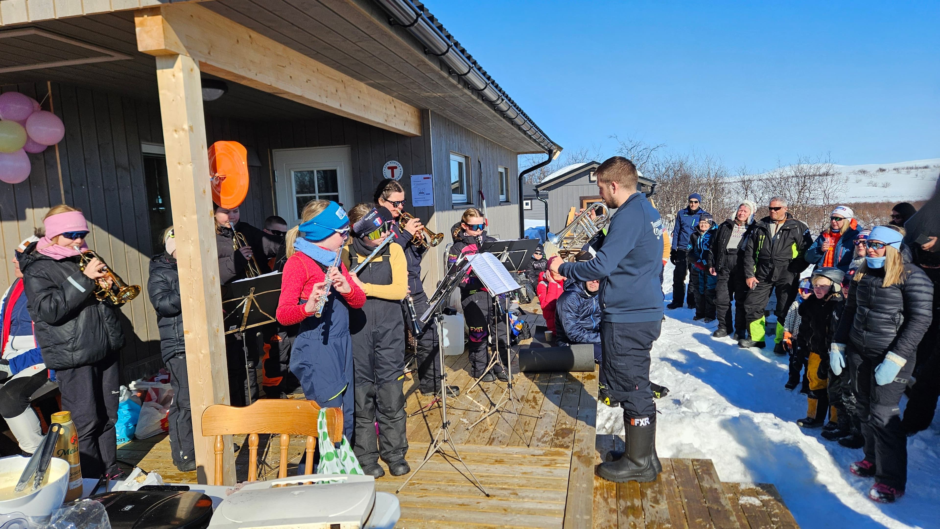 Bilde av hytta med masse folk foran