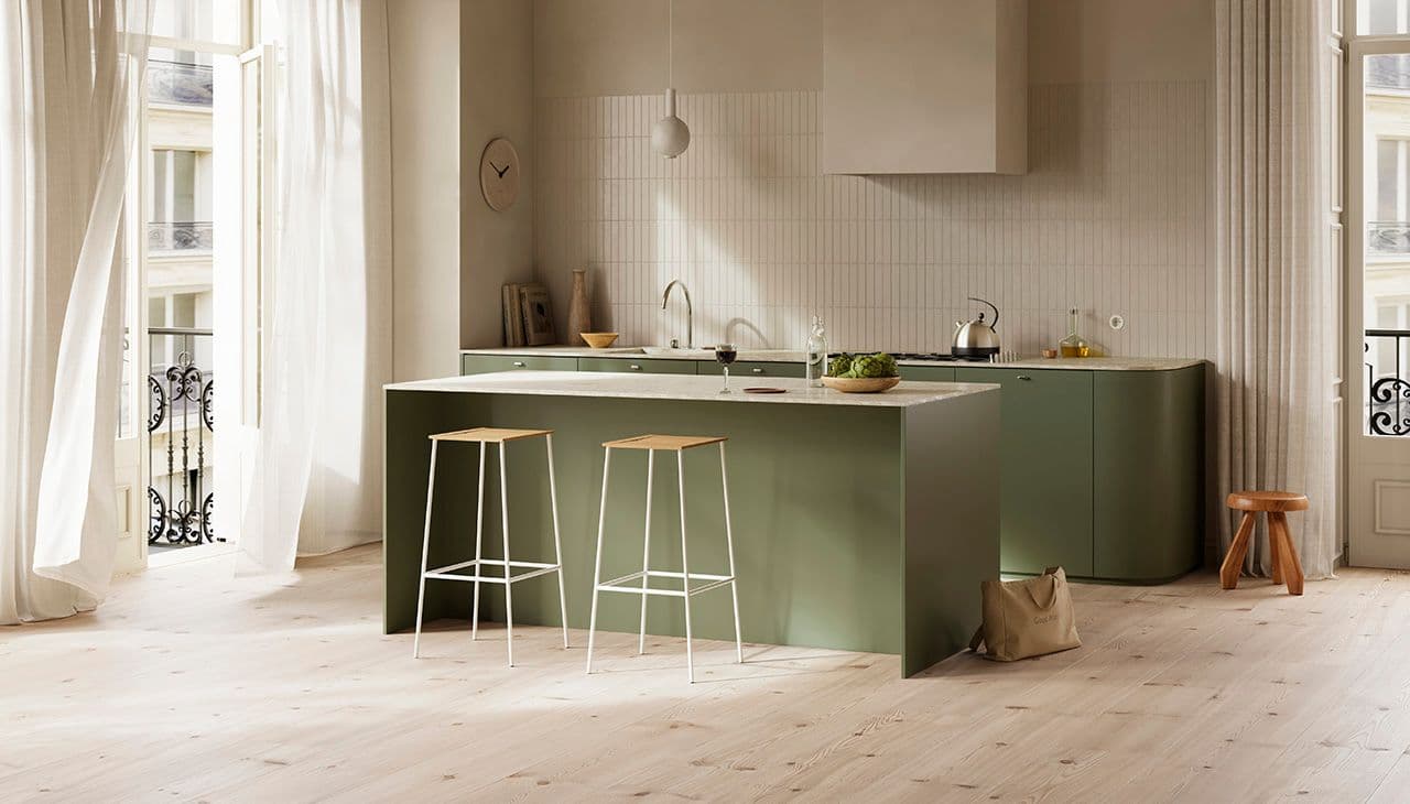 Grønt og beige kjøkken med lyst furugulv i høytrykkslaminat.