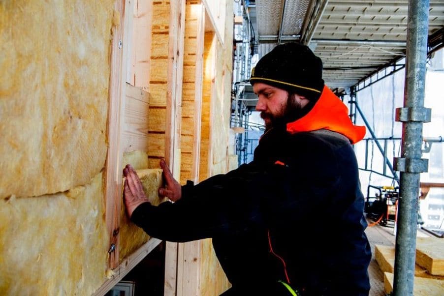 en mann som isolerer et hus