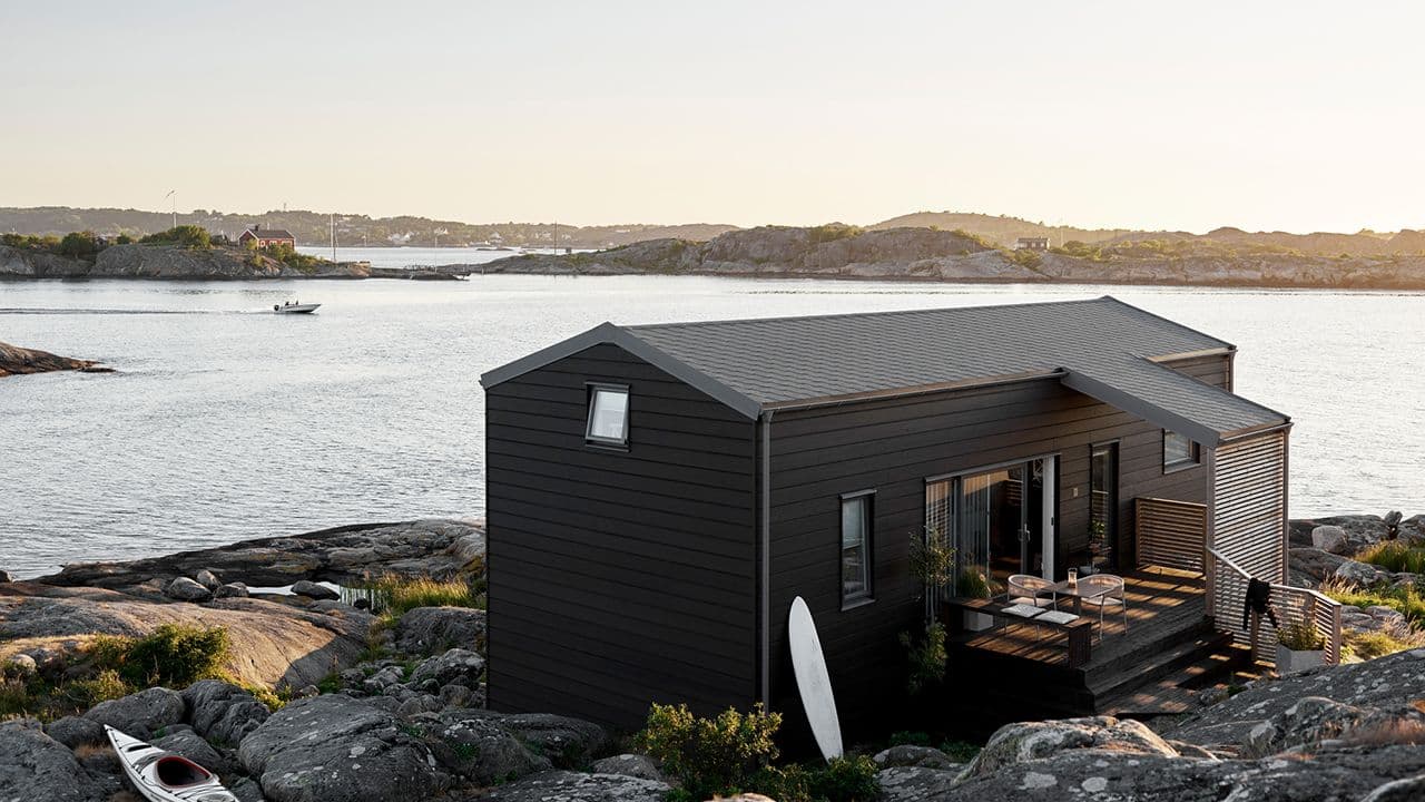 Hytte ved sjøen malt med hybridmaling Jotun DRYGOLIN Color Expert i fargen 90002 Gråsvart.