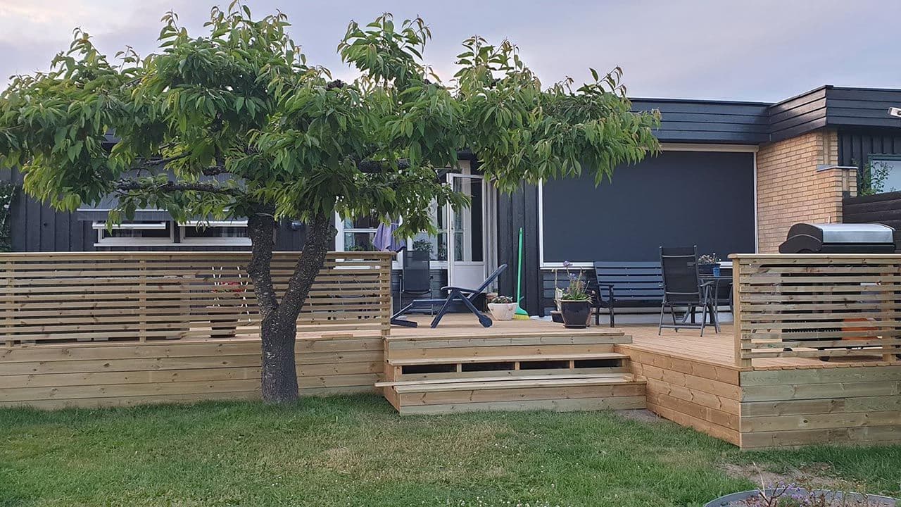 Stor terrasse med rekkverk i liggende spiler.