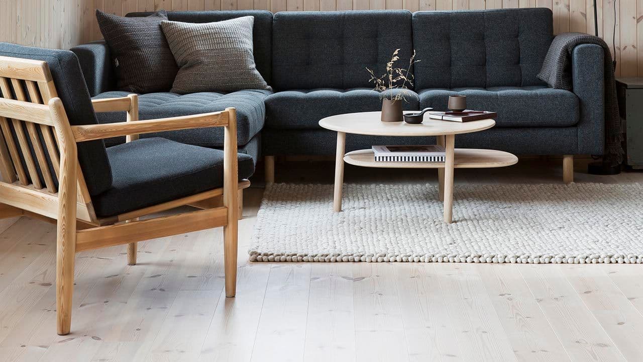 Stue med lys trepanel og furugulv.