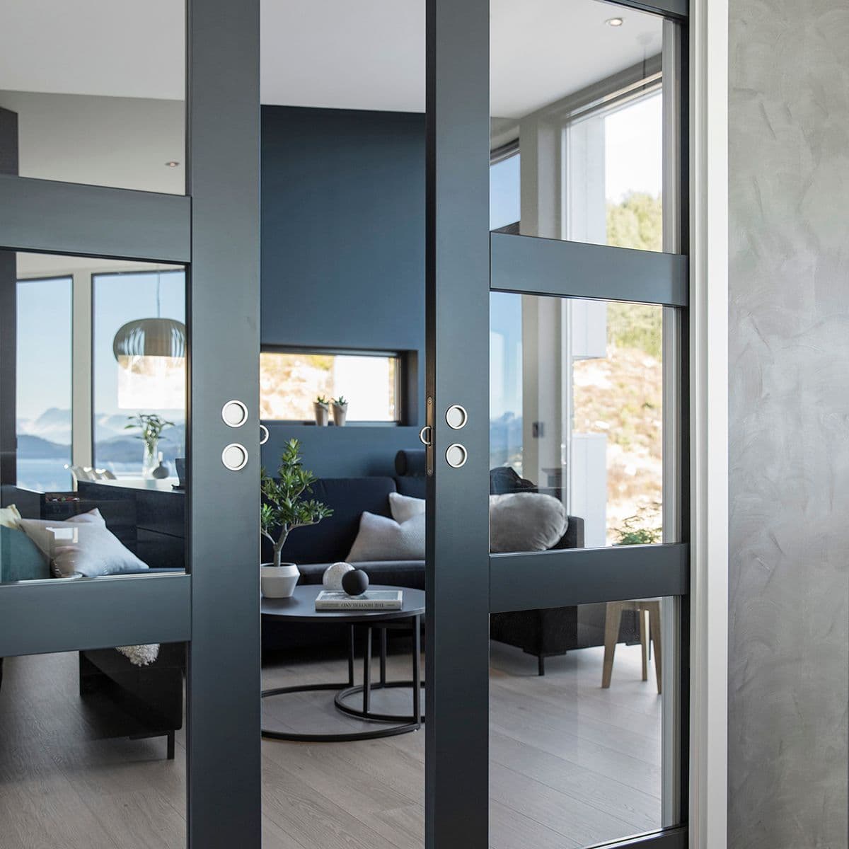 sorte skyvedører inn til en stue
