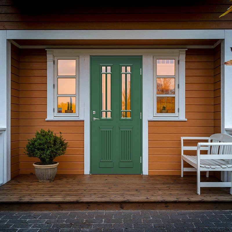 grønn ytterdør på et gult hus