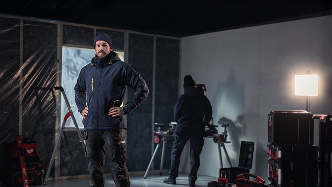 Mann som viser frem blå vinterjakke fra Blåkläder.