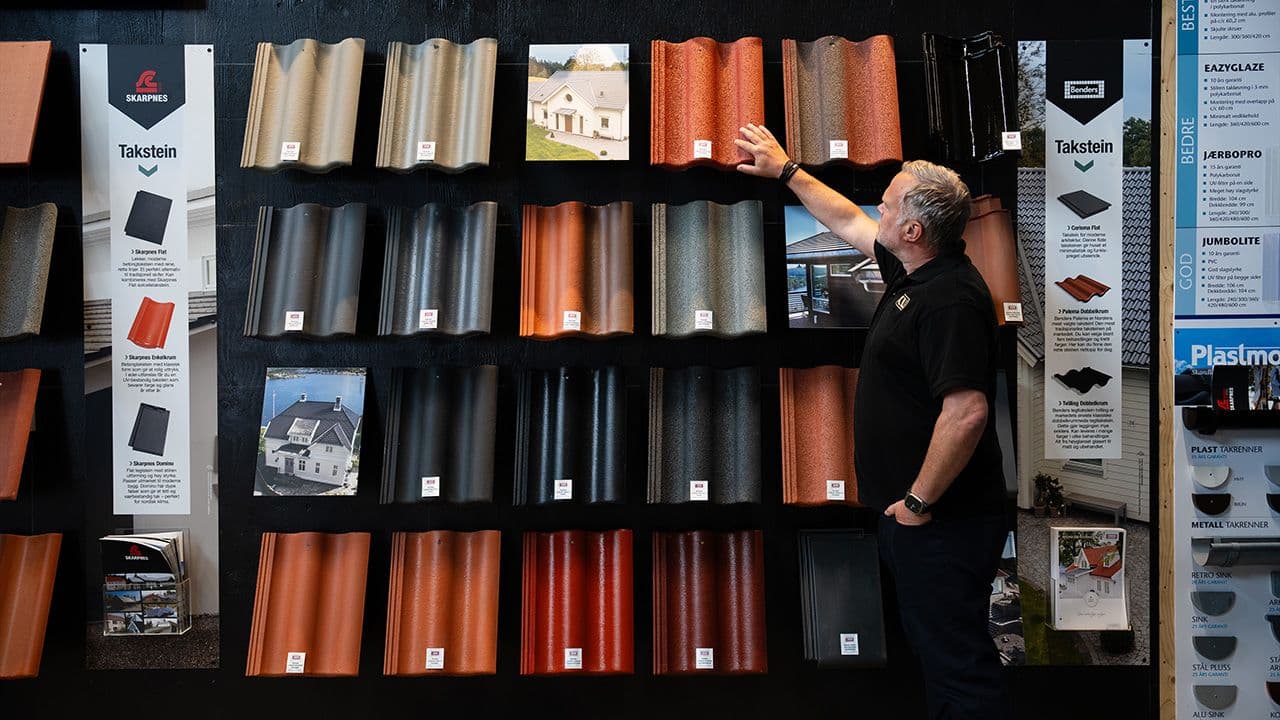 Ansatt hos XL-BYGG som viser frem ulike takstein-typer.