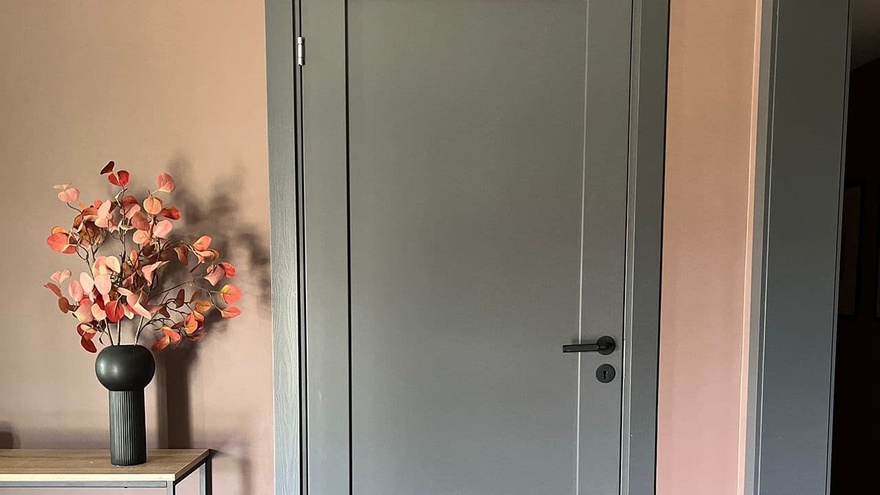 Gang med rosa vegger og grå innerdør