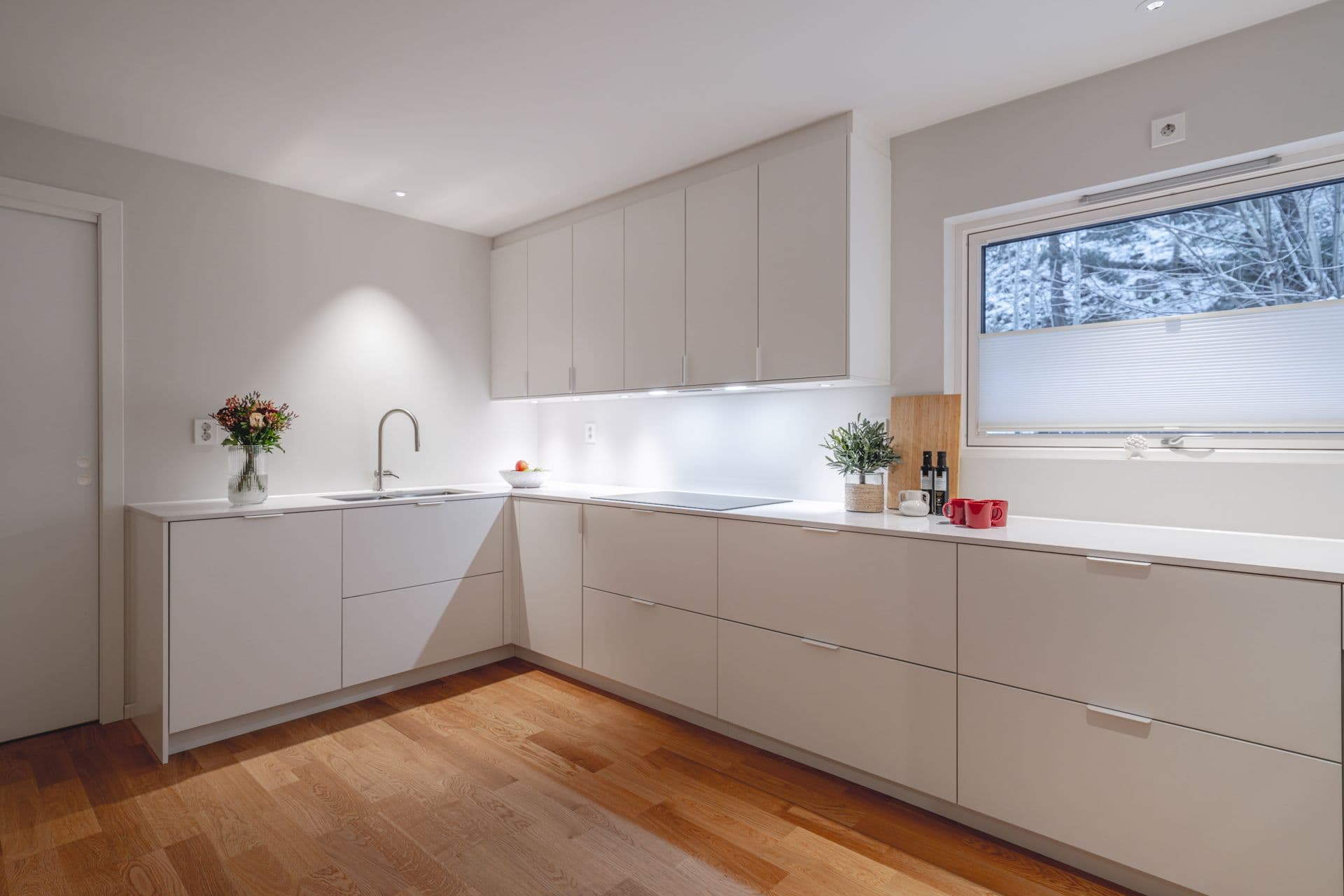 Moderne hvitt kjøkken med 2-stavsparkett i eik.