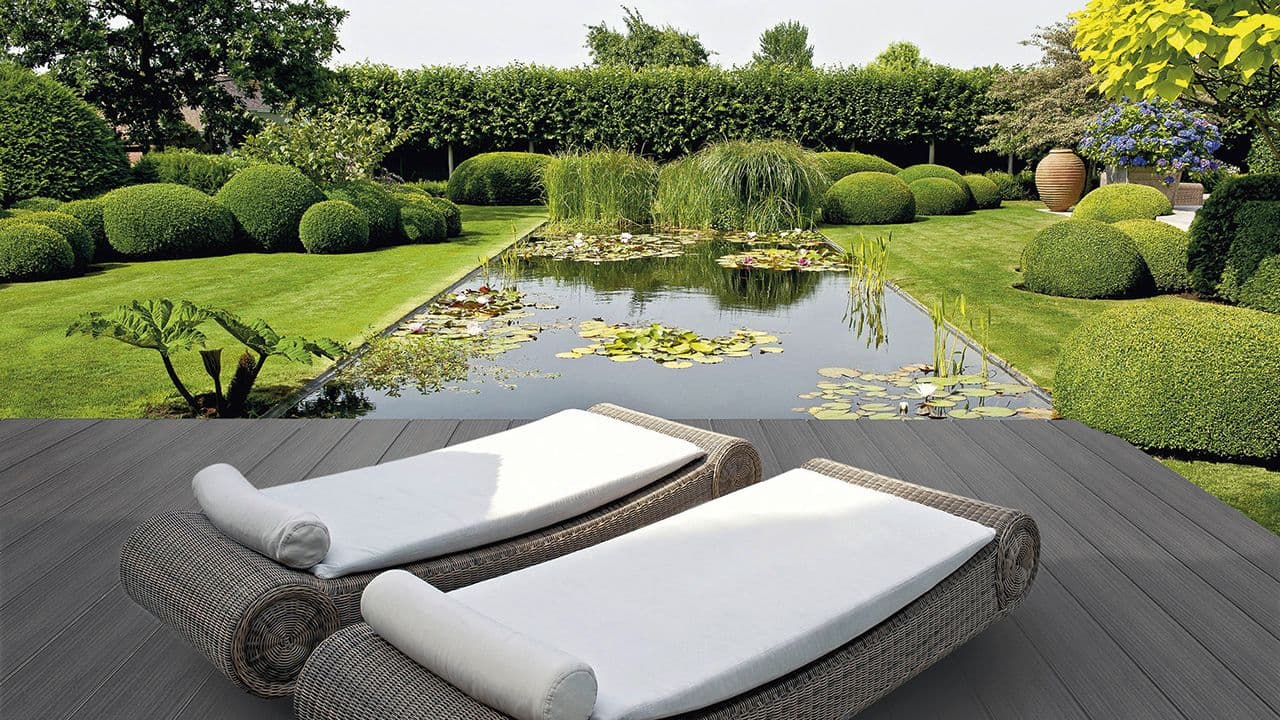 Terrassebord i kompositt på terrasse med solsenger ved pyntedam.