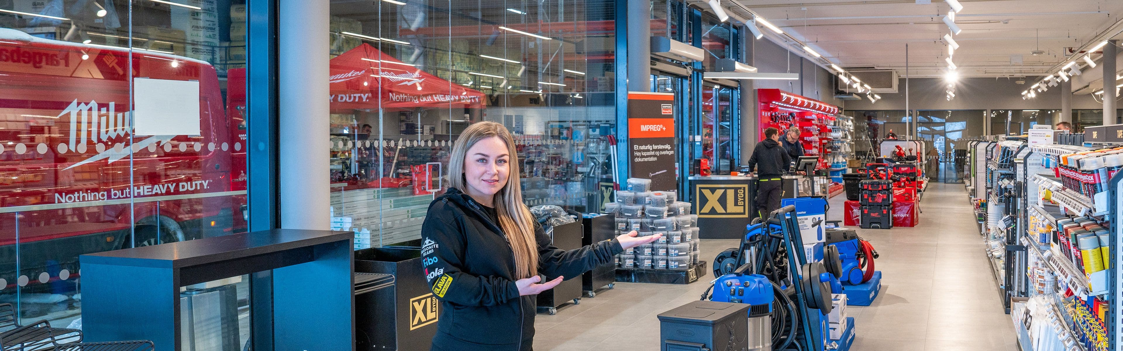 Interiørbilde av XL-BYGG Lofoten og ansatt Kristina som ønsker velkommen