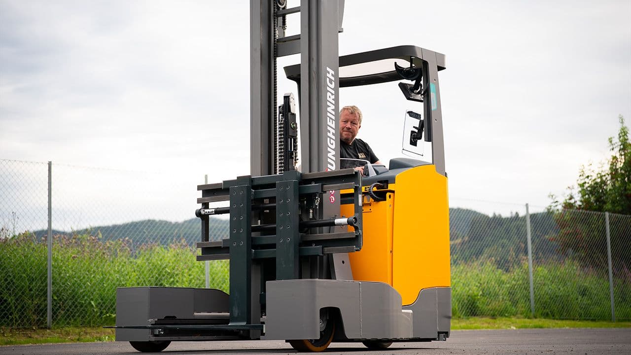 XL-BYGG ansatt som kjører en truck på parkeringsplass.