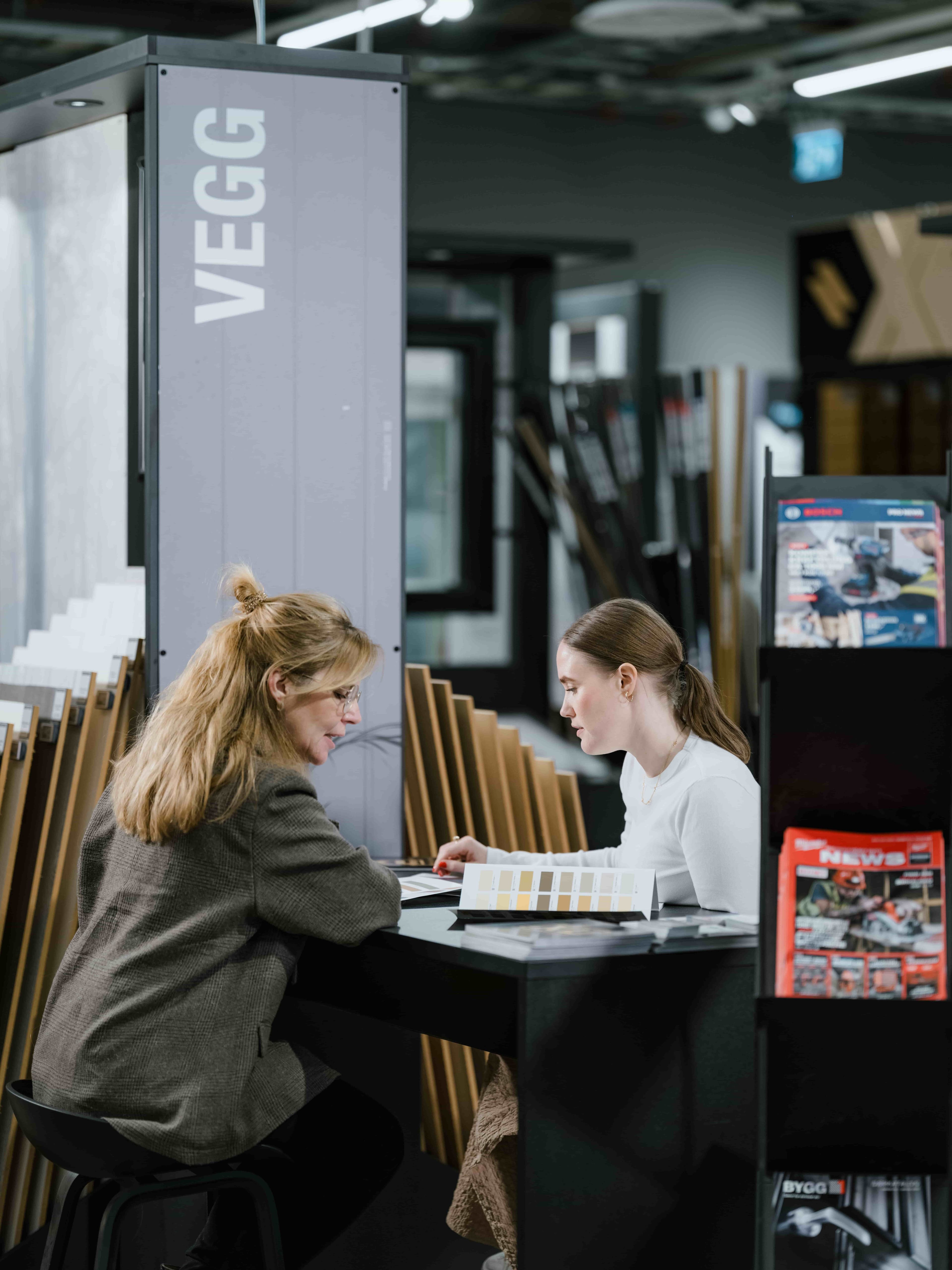 Kunde i butikk som får hjelp til å velge veggplater