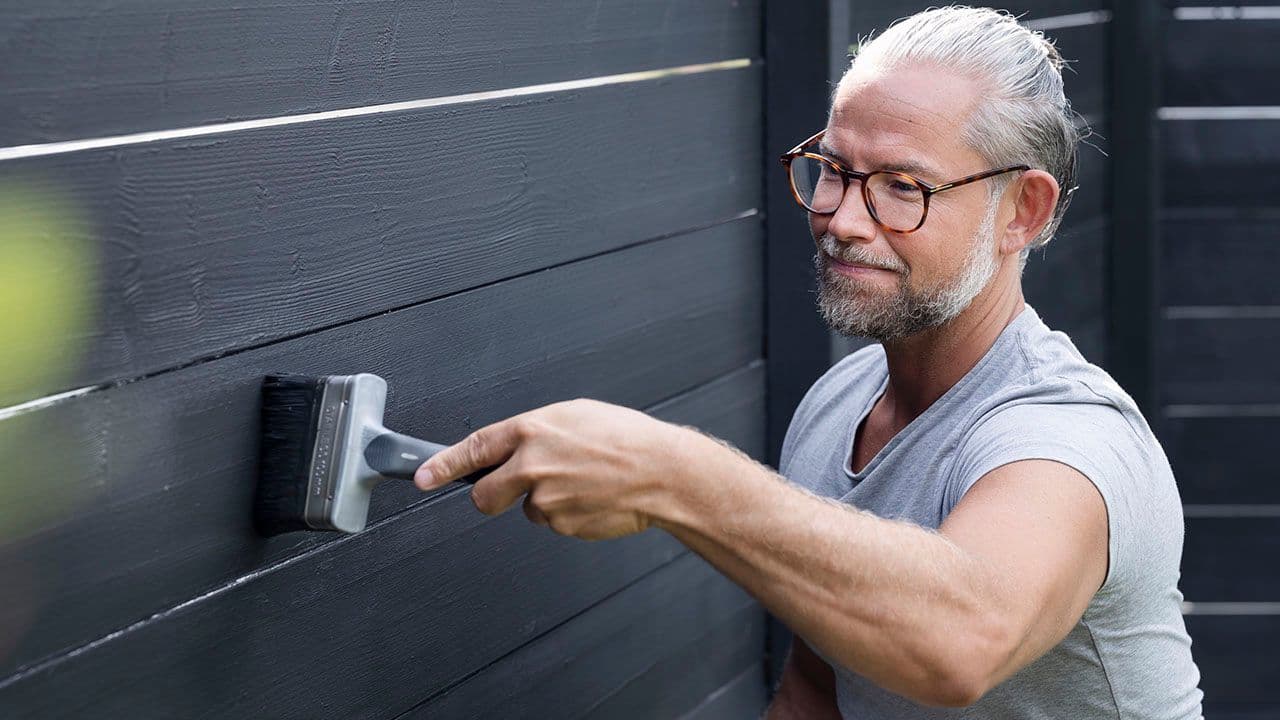 Mann som maler med Jordan Pensel Hus & Gjerde Ultimate 100 mm Vinklet.