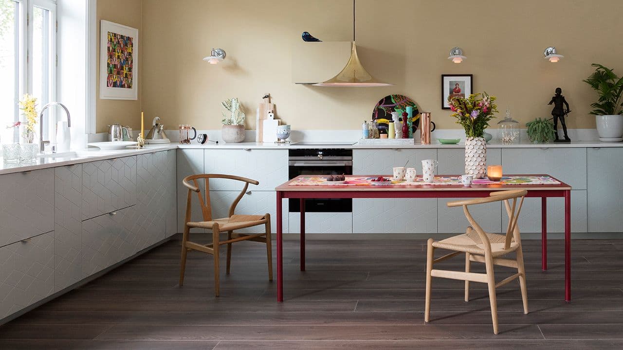 Mørkt gulv mot lys moderne kjøkkeninnredning.