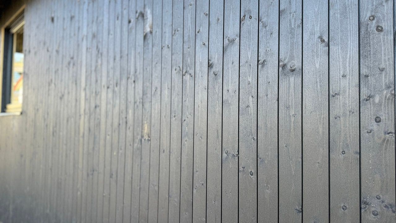 Husvegg med sort Moelven Heftig kledning med skjult innfesting.