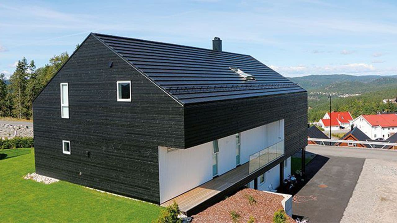 Moderne funkishus i svart med sort tegltakstein av typen Domino fra Skarpnes.