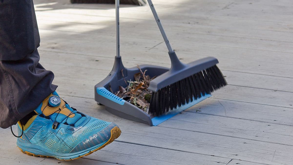 Løv og rusk feies opp fra en terrasse med Jordan feiekost og brett før vaske terrasse