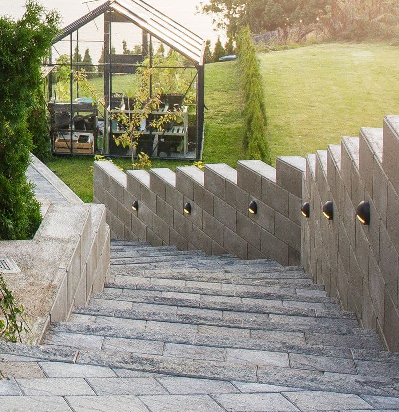 steintrapp ned mot drivhus med integrerte lys i muren