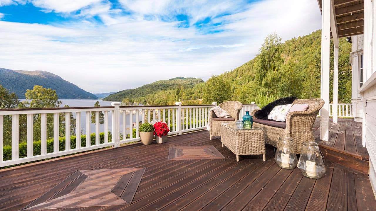 Stor terrasse med hvitt rekkverk i tre.