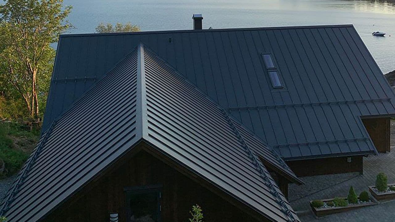 Hus ved sjøen med glatte takplater.